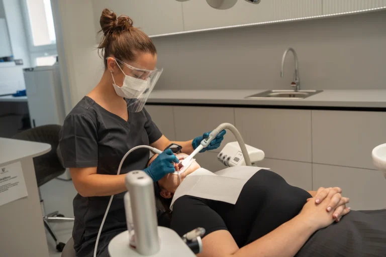 Dentální hygienistka ošetřuje pacienta
